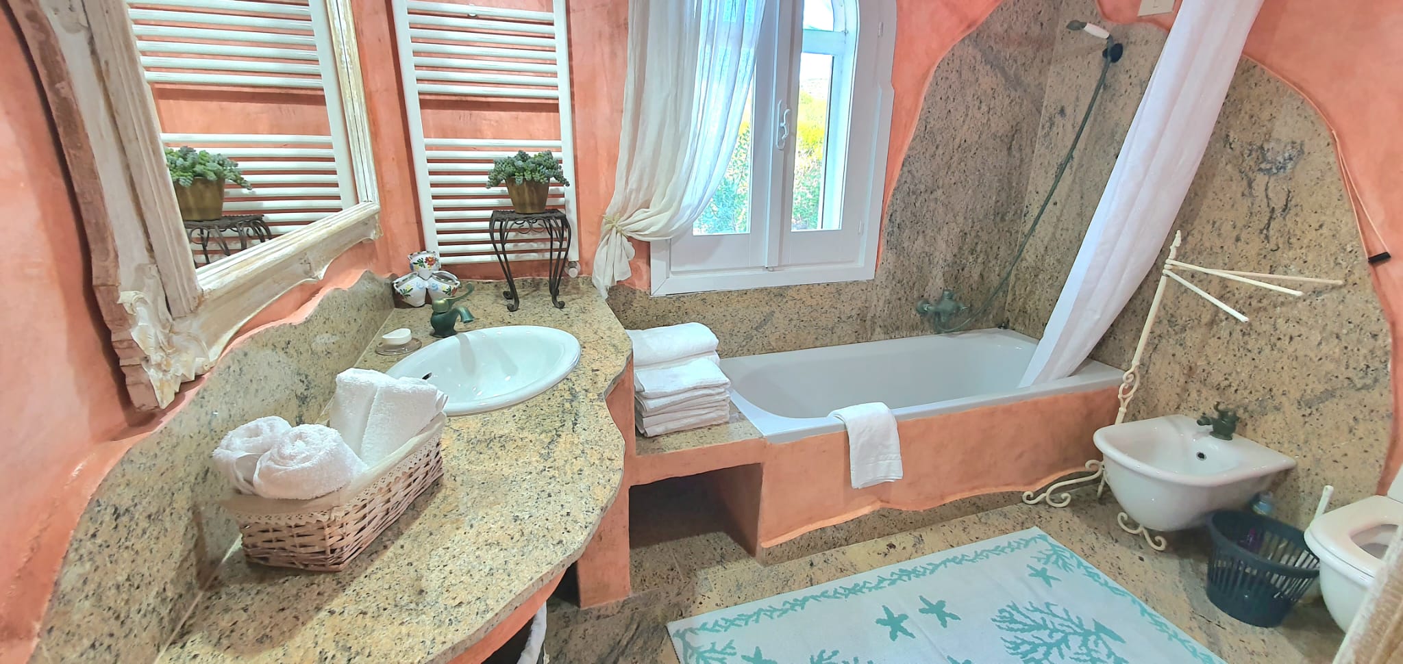 Badezimmer mit Badewanne und Terrakotta