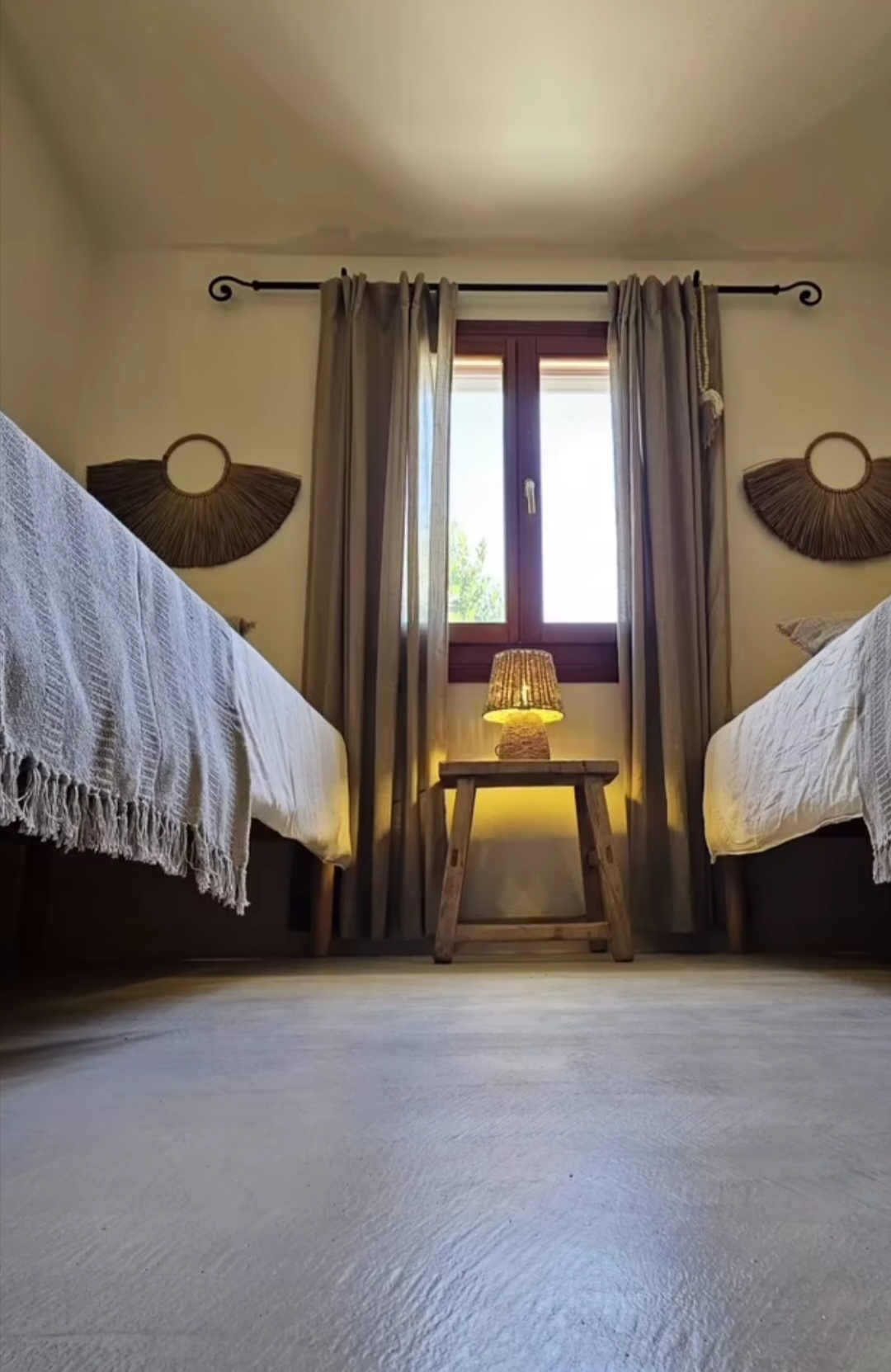Zweibett-Schlafzimmer mit Boho-Wanddeko und Holzhocker