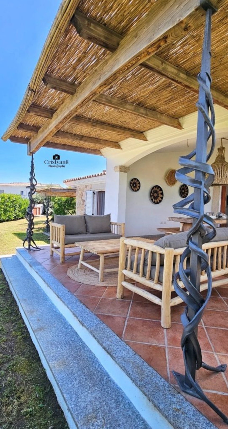 Terrasse mit Eisenskulptur und Boho-Wanddeko