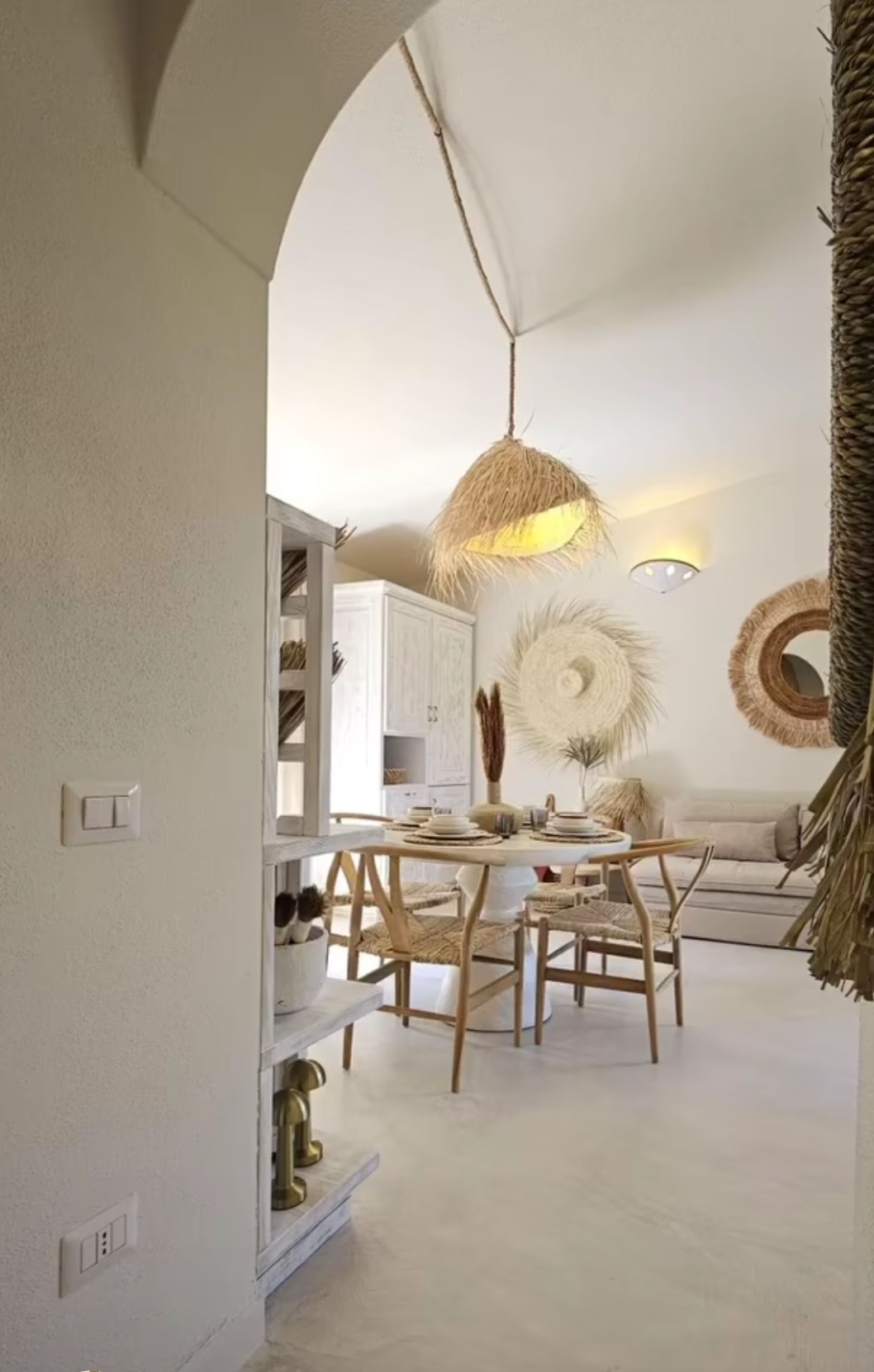 Wohnzimmer durch Rundbogen — Palmenlampe und Marmortisch