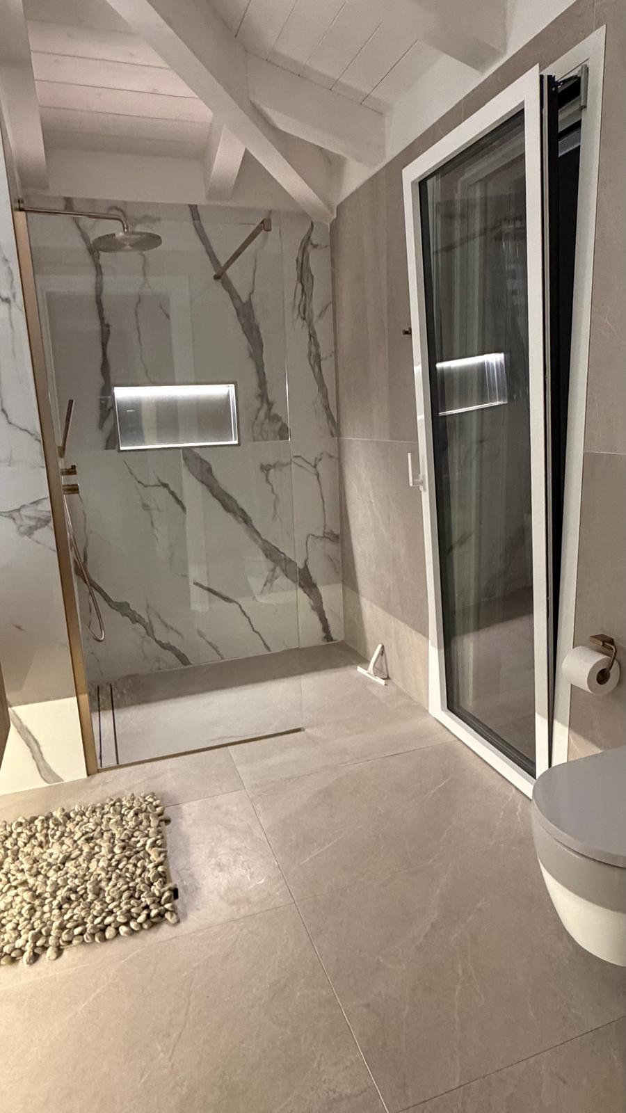 Dusche mit Marmorwand